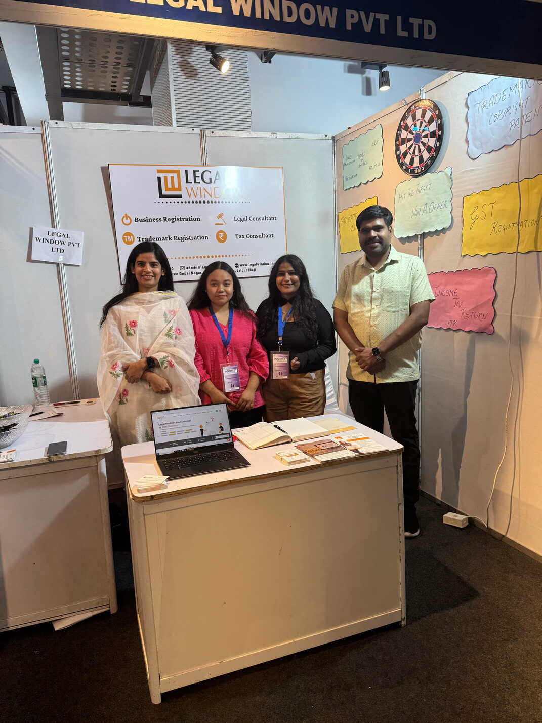 The team standing at the Legal Window stall at an exhibition
